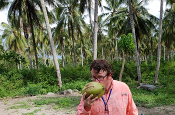 Ben Mason drinking from a coconut.