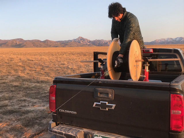 Matt Mendoza respooling fiber optic cable in the back of a pickup truck.