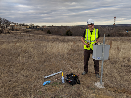 Paul Friberg with seismometer in field in Oklahoma.