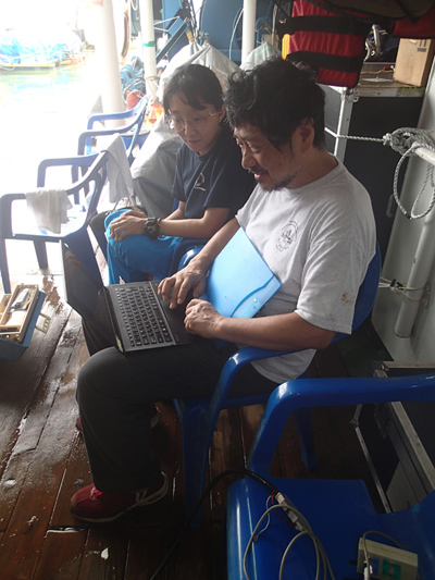 HyeJeong Kim and Hajime Shiobara observing how the first data checks are performed right after the recovery of an ocean bottom seismometer during the Oldest-1 cruise.