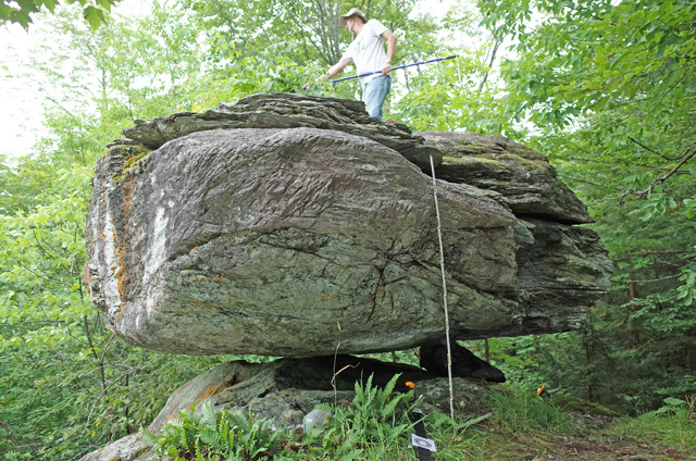 Precariously balanced rock in Westfield, Vermont, with Tom Pratt standing on top.
