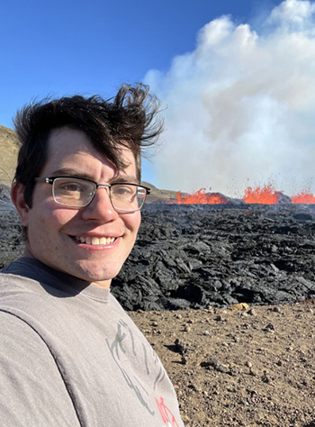 Julian Lozos stands in front of lava from the 2022 Meradalir eruption in Iceland.