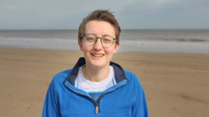 Rebecca Colquhoun at the beach in blue jacket